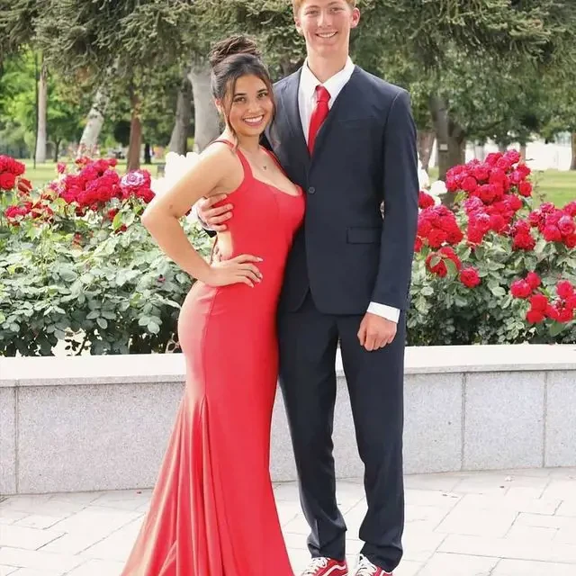 Сouple wearing a red gown and a black suit