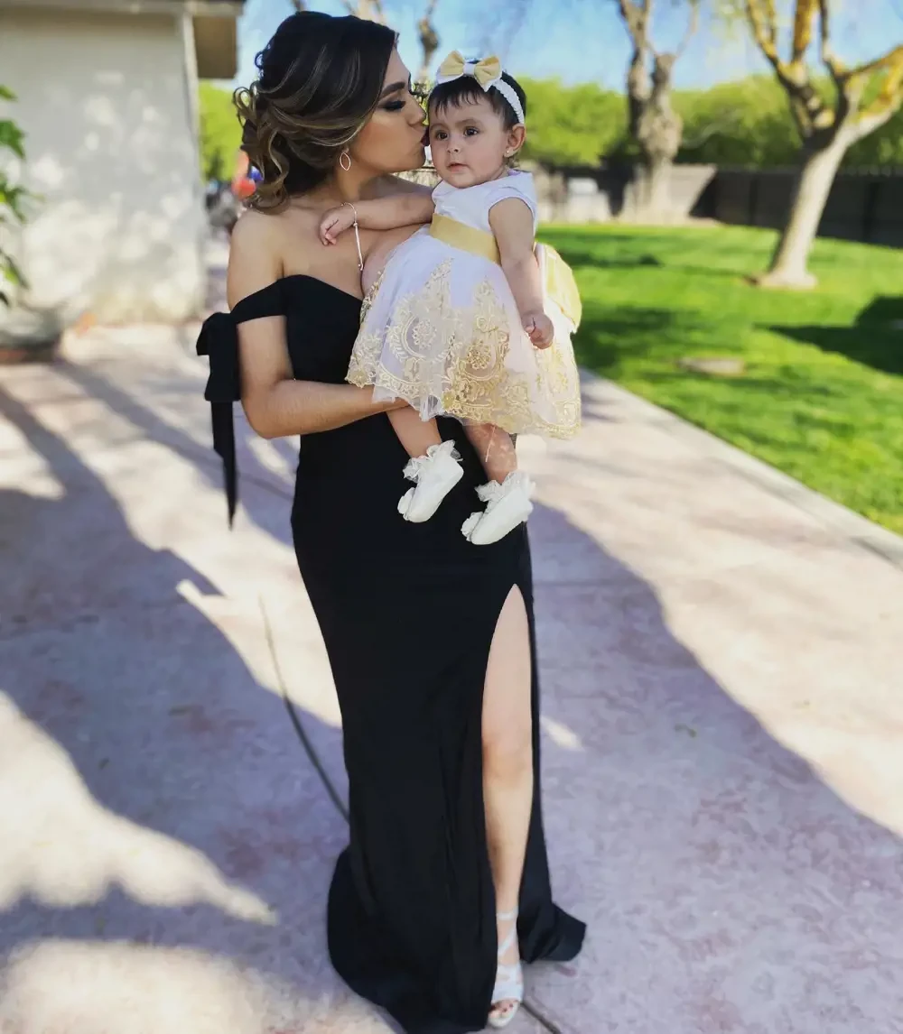 Model wearing a black gown with a child
