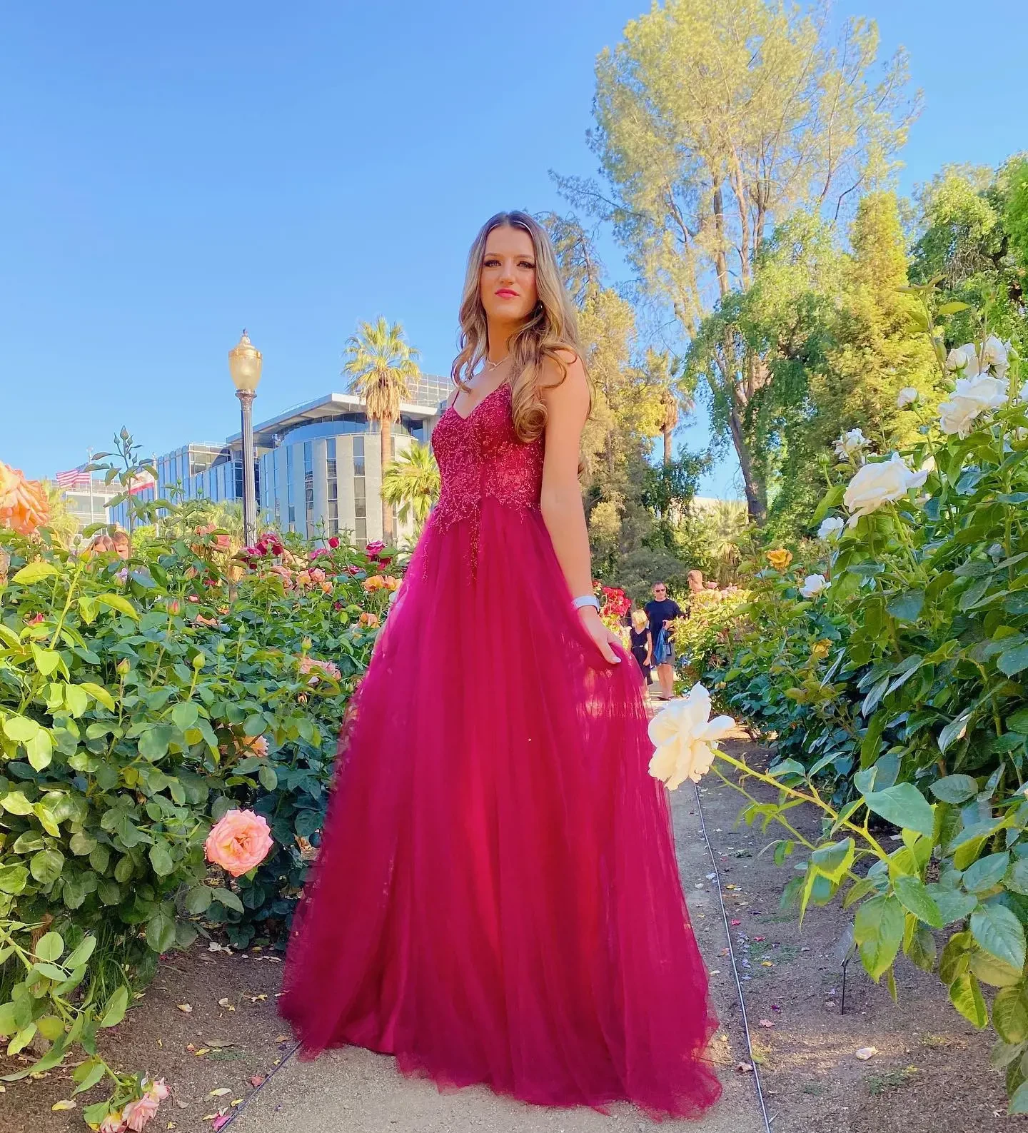 Model wearing a red dress near the flowers